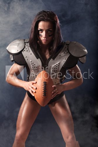 quarterback girl with a ball in the smoke  Sport Fototapeta