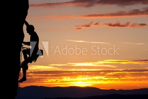 silhouette of climber on rock face  Sport Fototapeta