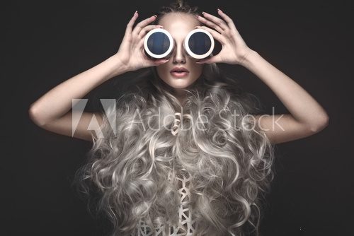 Beautiful girl in art dress and avant-garde hairstyles with cosmetic products in her hands. Beauty face. Photos shot in the studio. Fototapety do Salonu Fryzjerskiego Fototapeta