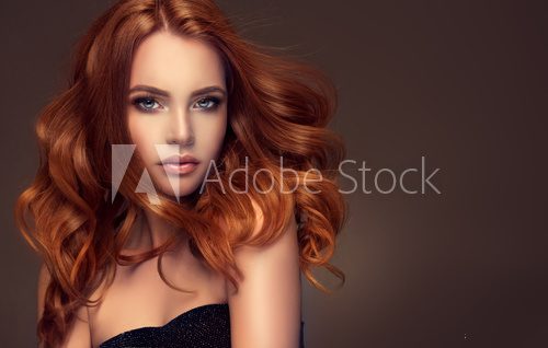 Beautiful model girl with long red curly hair .Red head . Care products ,hair colouring . Fototapety do Salonu Fryzjerskiego Fototapeta
