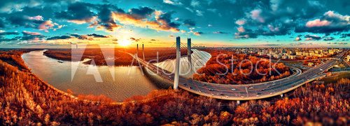 Beautiful panoramic aerial drone view to cable-stayed Siekierkowski Bridge over the Vistula river and Warsaw City skyscrapers, Poland in gold red autumn colors in November evening at sunset Mosty Obraz
