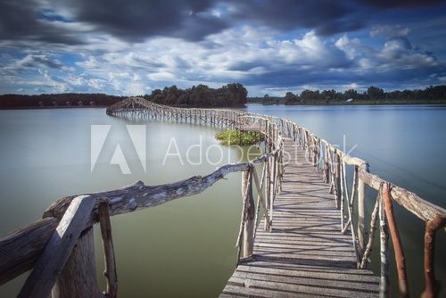 Drewniany most wijący się nad spokojnym jeziorem Fototapety Mosty Fototapeta