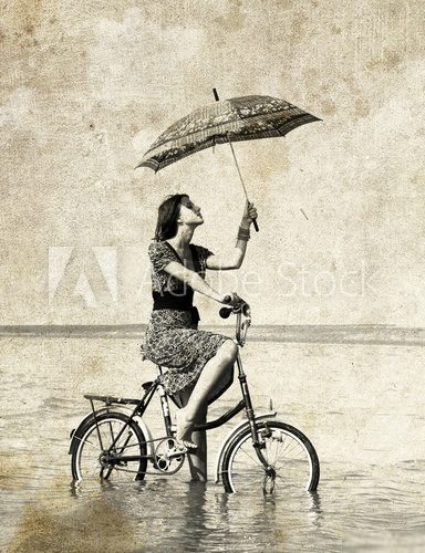 Girl with umbrella on bike Photo in old image style Plakaty do Salonu Plakat