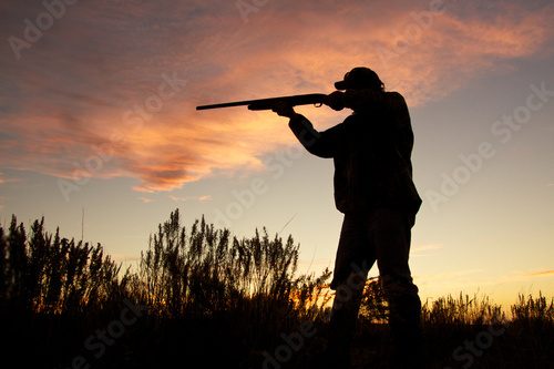 Hunter Silhouetted Shooting at Sunset Obrazy do Salonu Obraz