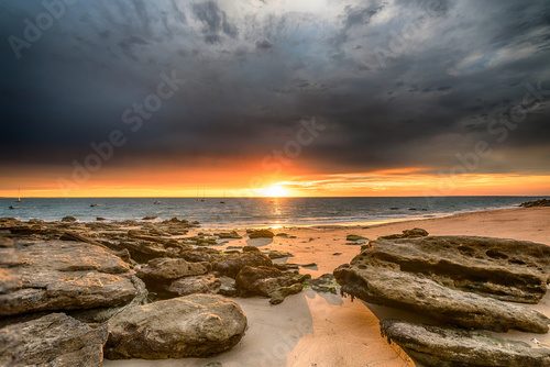 Magiczny zachód słońca nad skalistą plażą Zachód Słońca Fototapeta