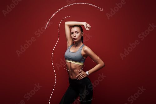 Power and beauty. Sportswoman standing over red background, looking away. Graphic drawing. Fototapety do Klubu Fitness Fototapeta