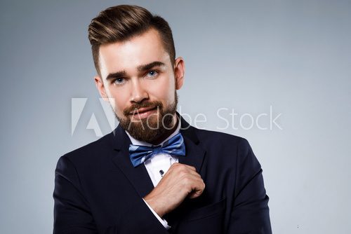 Stylish handsome man wearing a classic suit with bow-tie Fototapety do Salonu Fryzjerskiego Fototapeta