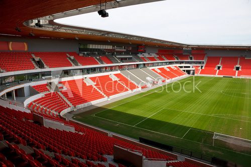 View on an empty football (soccer) stadium with red seats  Stadion Fototapeta