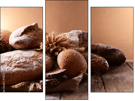 Different bread on table on brown background  - Obraz trzyczęściowy, Tryptyk